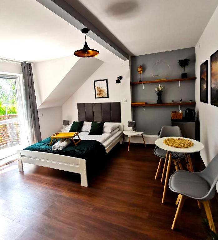 a bedroom with a bed and a table at Srokówka Resort in Dąbrówka