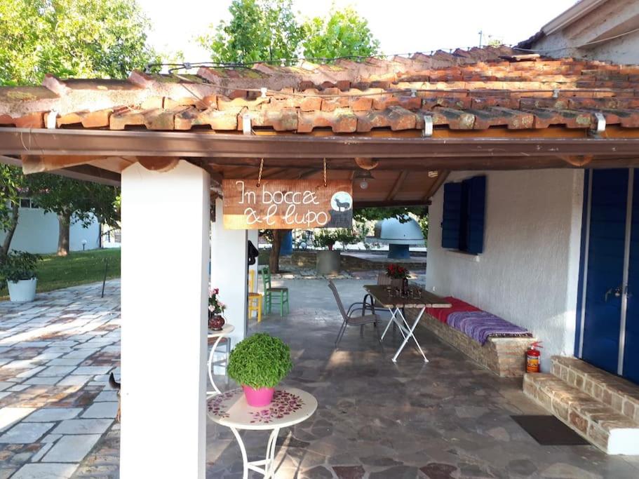 un patio con una mesa y un cartel en un edificio en Κτήμα Archaia Ilida, en Avyíon