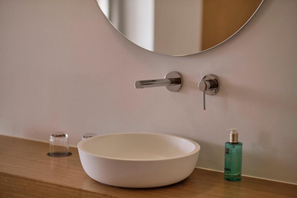 a bathroom with a bowl sink and a mirror at Las Gaviotas Suites Hotel & Spa in Playa de Muro