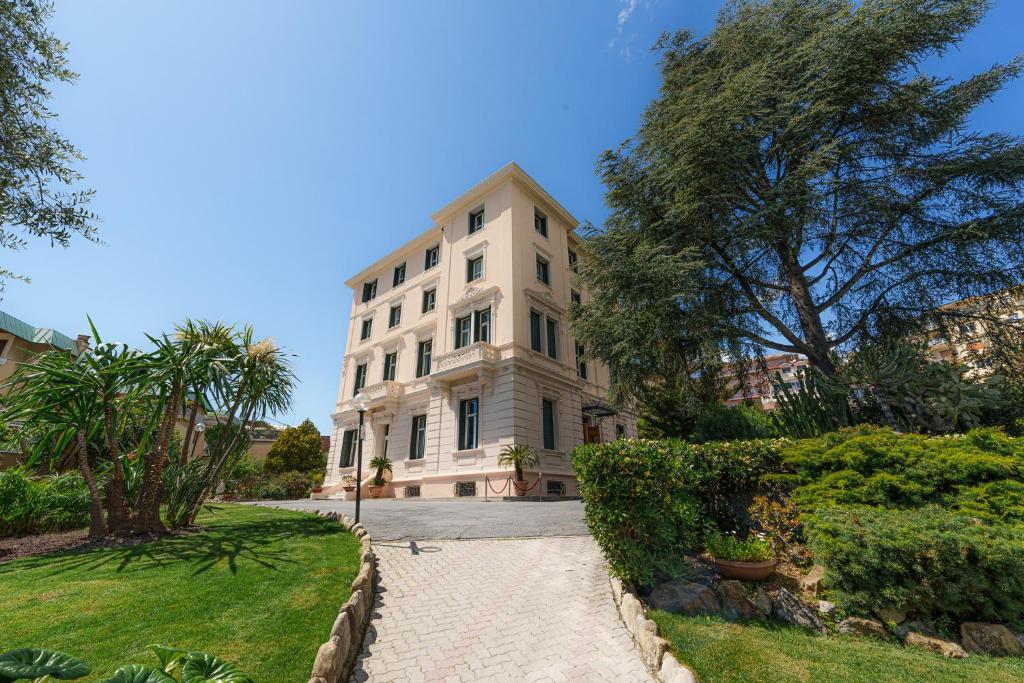 duży biały budynek z drzewami przed nim w obiekcie Hotel Villa Levi w San Remo