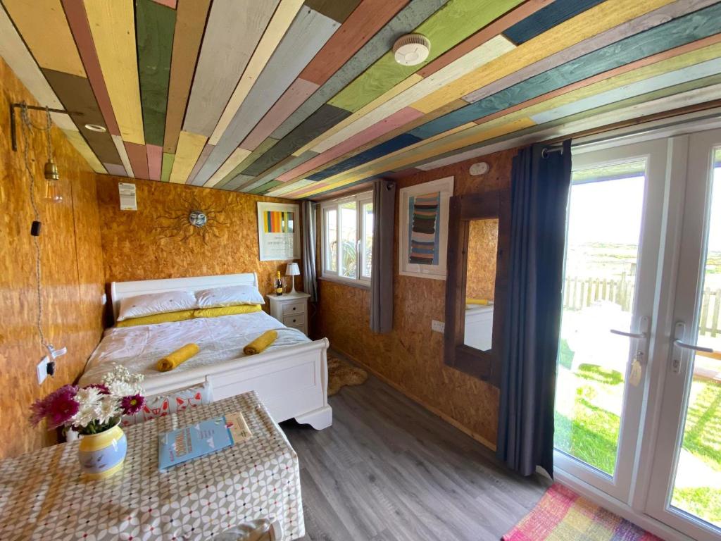 a bedroom with a bed and a coffered ceiling at Sunrise Cabin in Carbis Bay