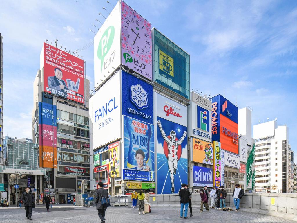 大阪的住宿－VESSEL INN NAMBA，一群人带着标志在城市里行走