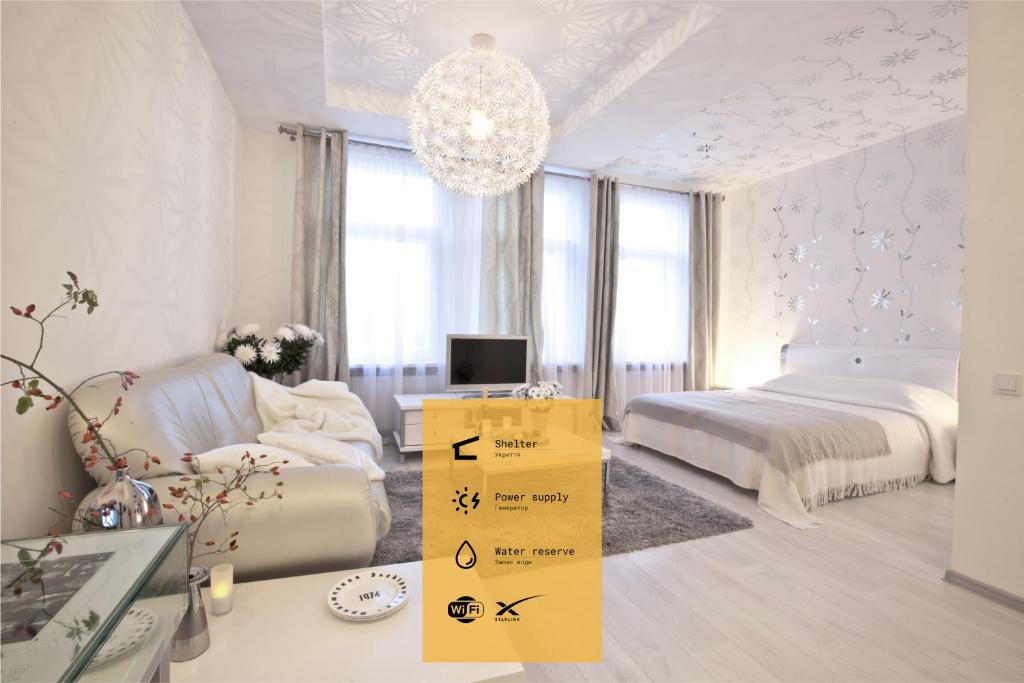 Habitación blanca con cama y lámpara de araña. en Hotel Dom Aktera en Odesa