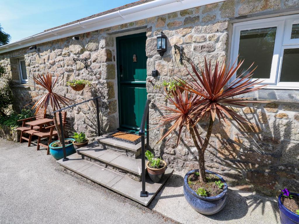 a stone house with potted plants in front of it at Chy-An-Oula in Falmouth