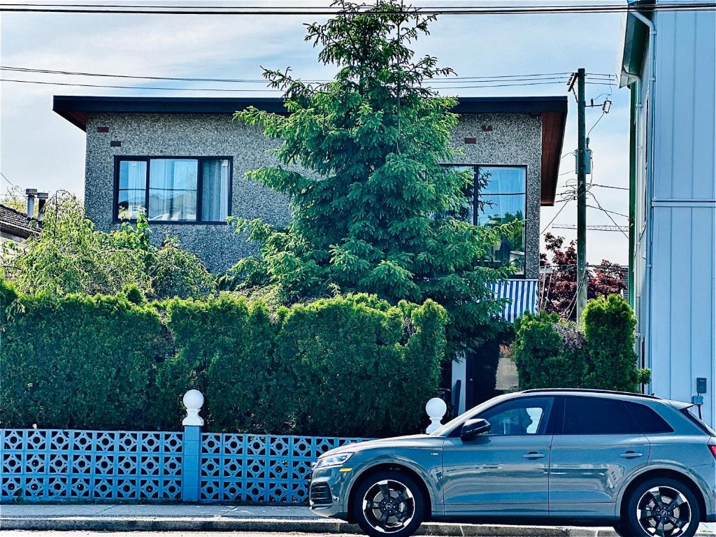 a blue car parked in front of a house at Adorable Main Street Haven in Vancouver