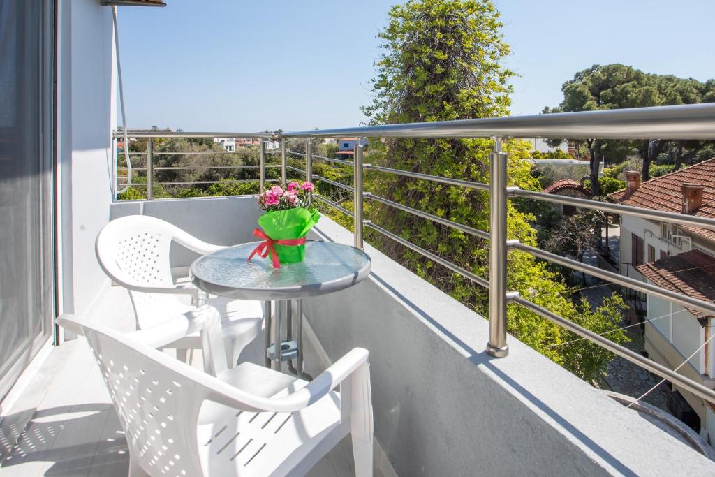 a balcony with a table with flowers on it at Economisa Apartments in Ialysos