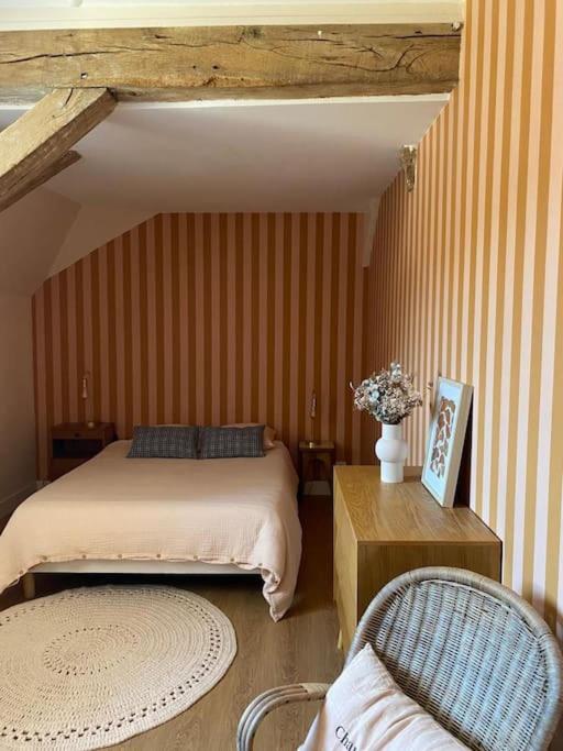 une chambre avec un lit, une table et des chaises dans l'établissement L'appartement d'Armentières, à Saint-Benoist-sur-Vanne