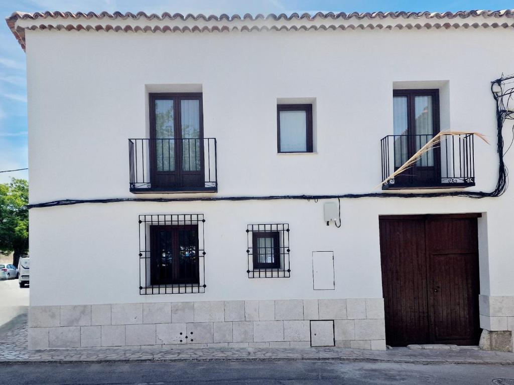 - un bâtiment blanc avec des fenêtres et une porte dans l'établissement La Casa de la Rufi, à Colmenar de Oreja