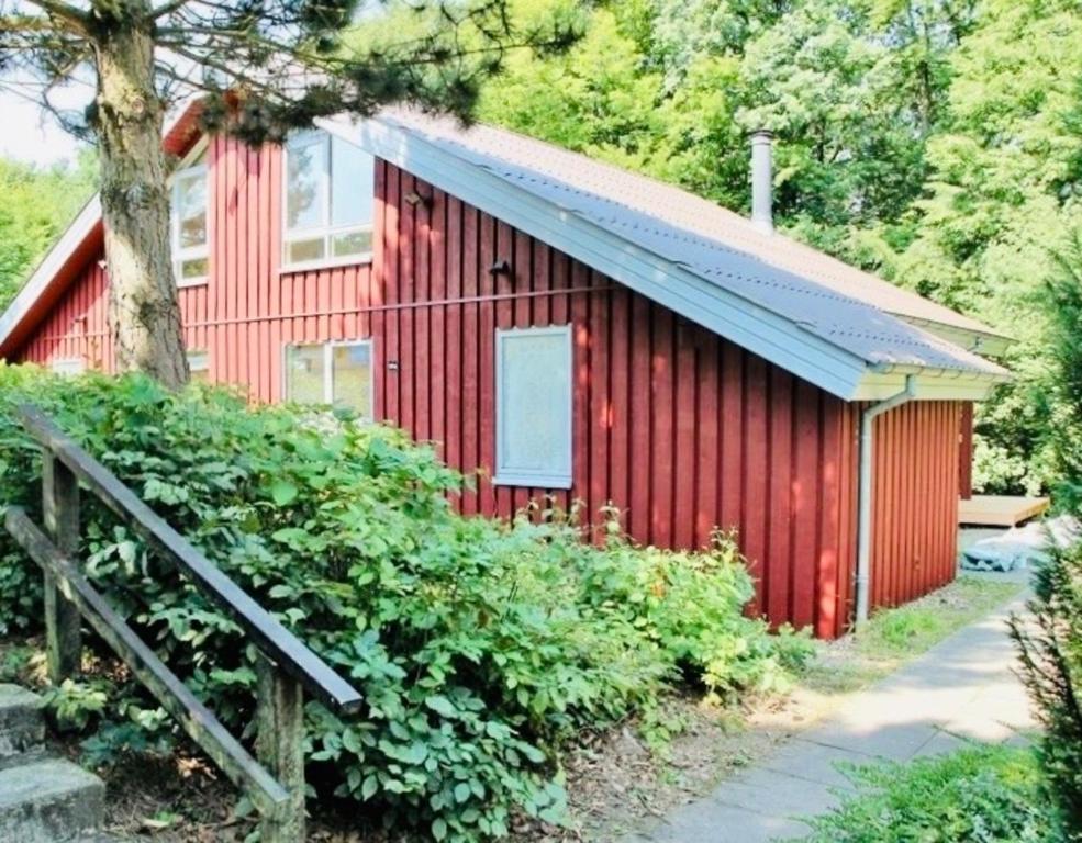 een rood gebouw met een gambrel dak bij Komfort-Ferienhaus - Extertal Ferienpark - Entspannung, Natur, Wald, Familie #51 in Extertal
