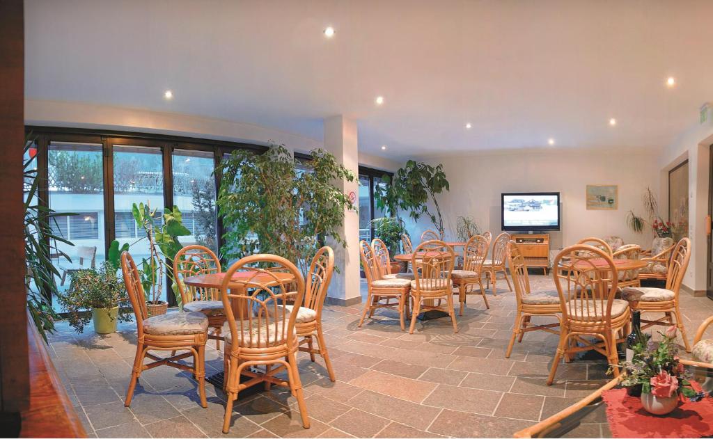 una sala da pranzo con tavoli e sedie in legno di Hotel Heinz a Brunico