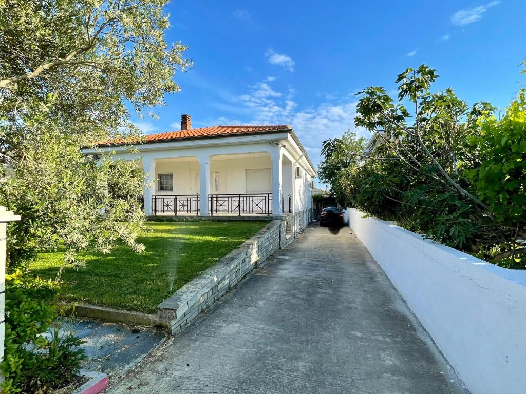 a white house with a pathway leading to it at My House in Paralia Messi in Aroyí