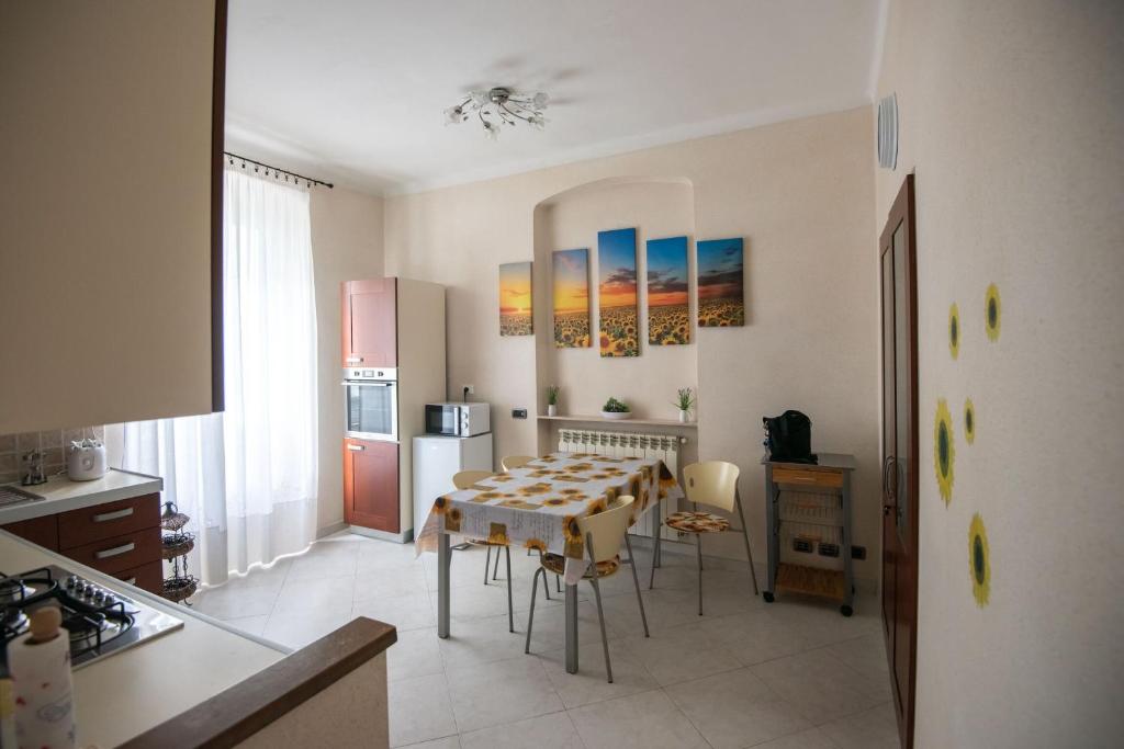 una cucina con tavolo e sedie in una stanza di La casa dei girasoli wifi e relax a Genova