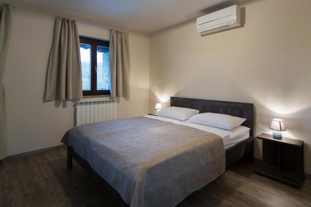 a bedroom with a bed with two pillows and a window at Guest House Valentincic in Nova Gorica
