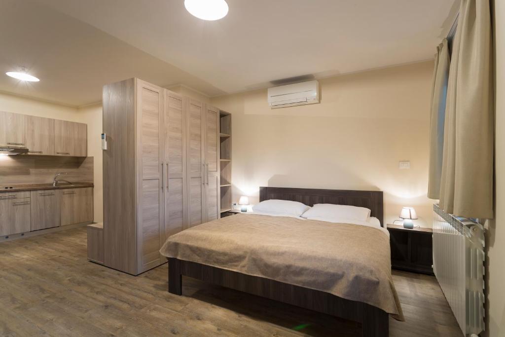 a bedroom with a large bed and a kitchen at Guest House Valentincic in Nova Gorica