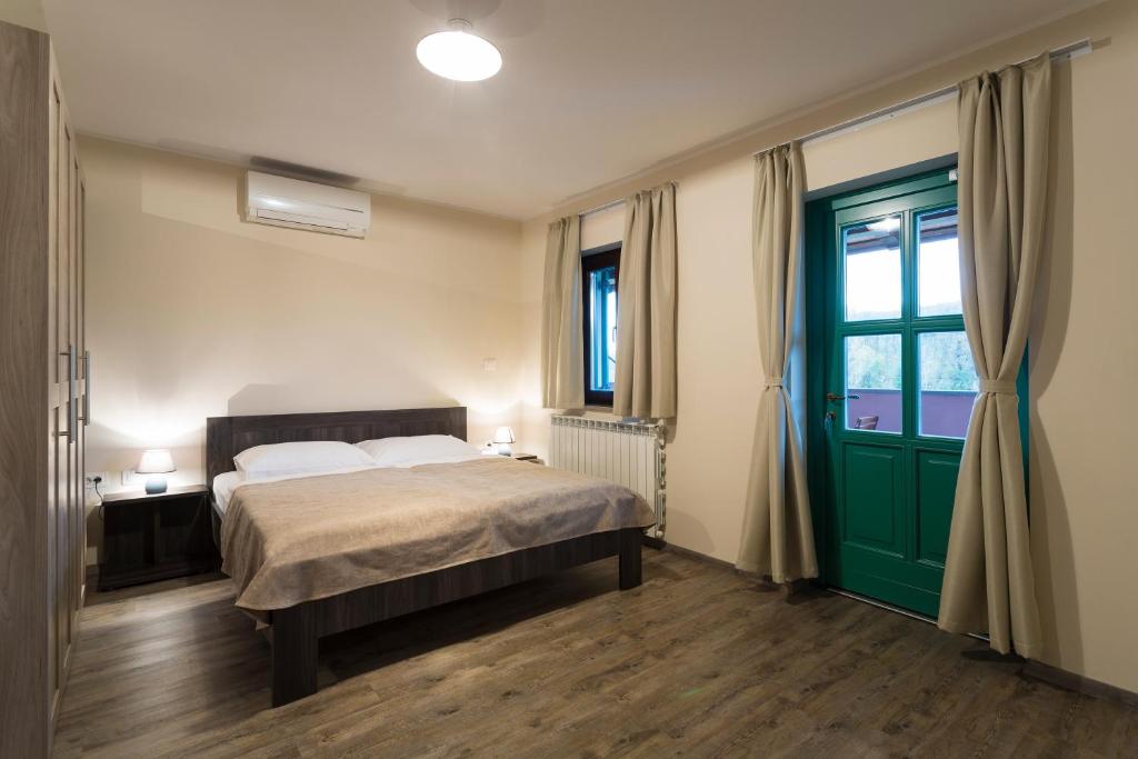 a bedroom with a bed and a green door at Guest House Valentincic in Nova Gorica
