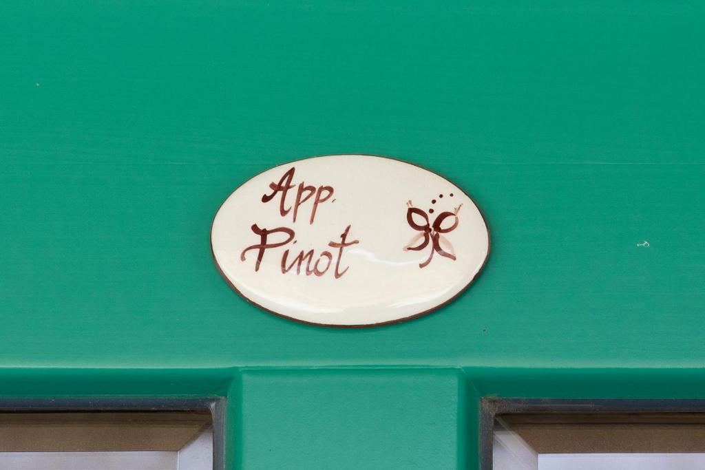 a sign on the top of a green wall at Guest House Valentincic in Nova Gorica