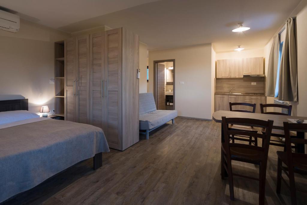 a bedroom with a bed and a table and a kitchen at Guest House Valentincic in Nova Gorica