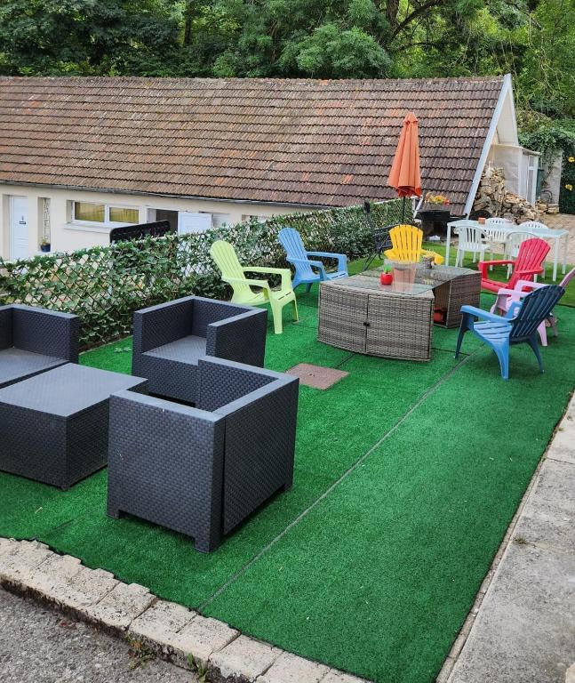 une cour avec des chaises et des meubles sur l'herbe dans l'établissement Le Bon Samaritain, à Roucy
