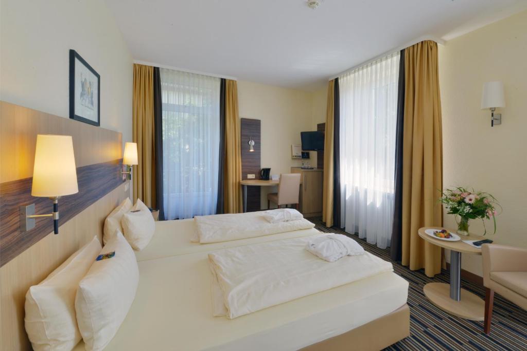 Postel nebo postele na pokoji v ubytování Kurpark-Hotel