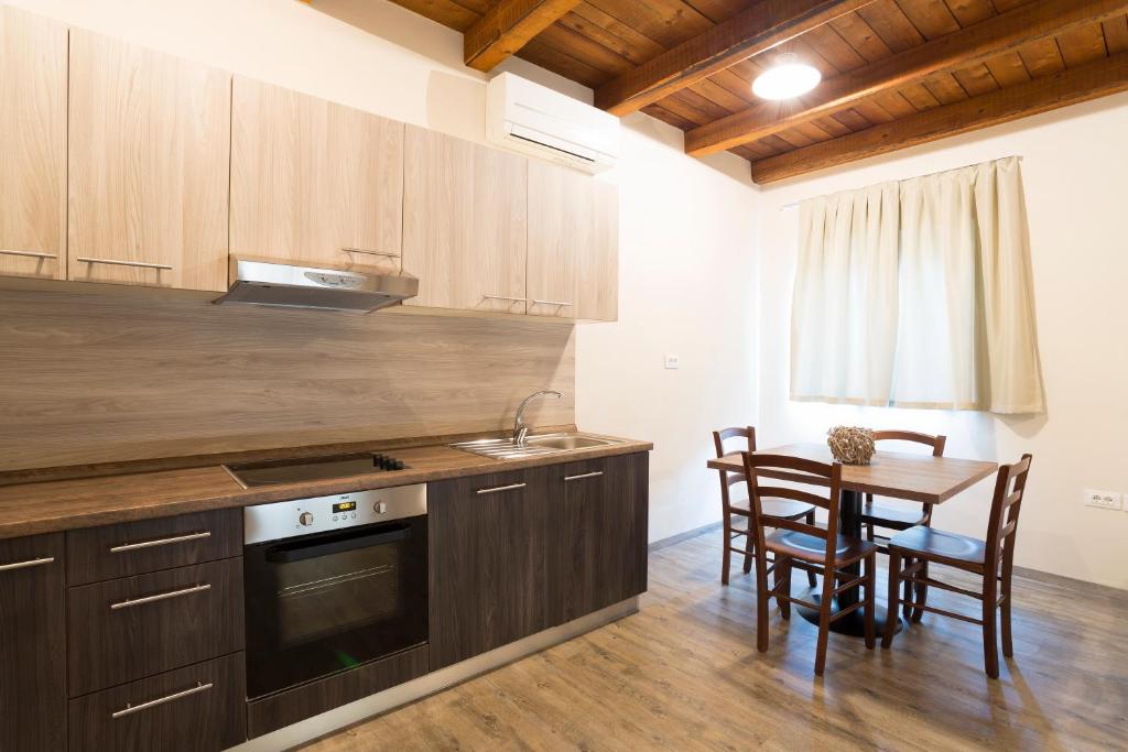 a kitchen with wooden cabinets and a table with chairs at Guest House Valentincic in Nova Gorica