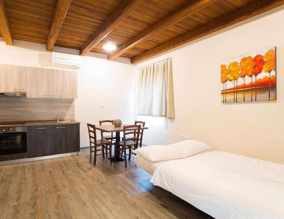 a bedroom with a bed and a table with chairs at Guest House Valentincic in Nova Gorica