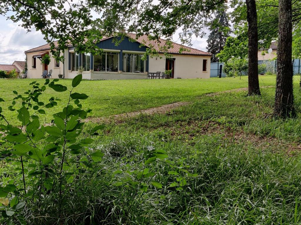 a house in a field with trees and grass at Les Chevêches in Milhac-dʼAuberoche