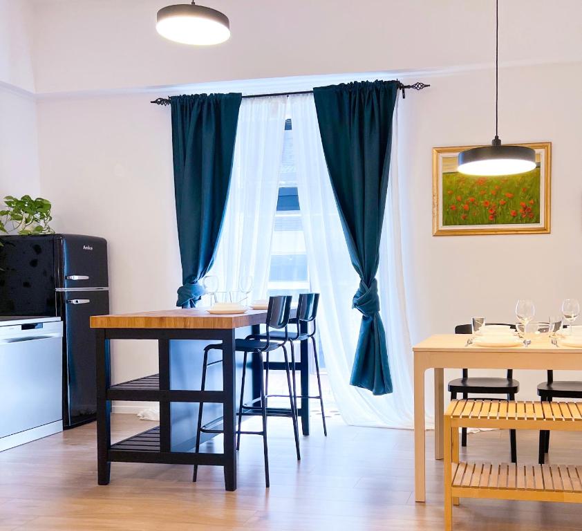 een eetkamer met een tafel en stoelen en een raam bij Aumetz square apartment in Idrija