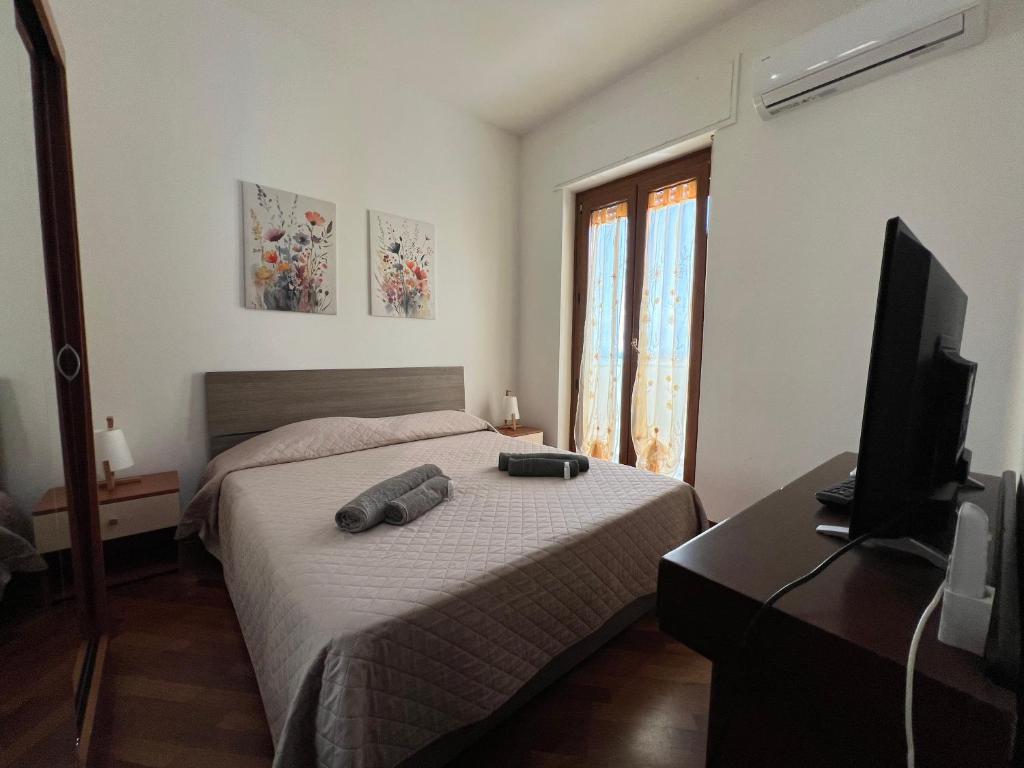 Schlafzimmer mit einem Bett und einem Flachbild-TV in der Unterkunft Petronia Home in Porto Torres