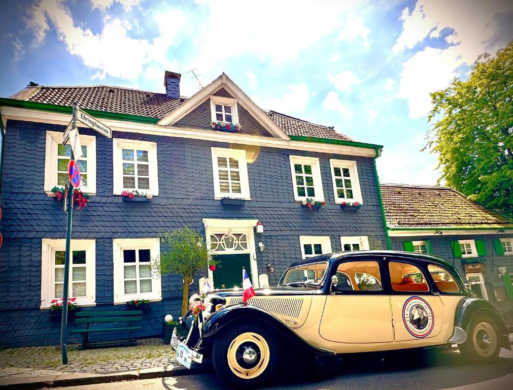 an old car parked in front of a blue house at Gästehaus Ehringhausen 63 (Anno 1719) in Remscheid