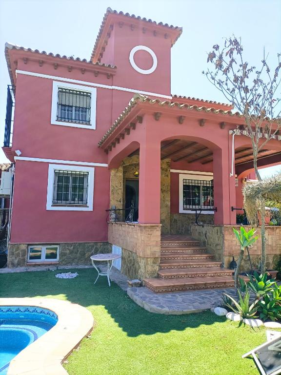 a red house with a pool in front of it at Villa Matisse Luxury Beach in Torremolinos