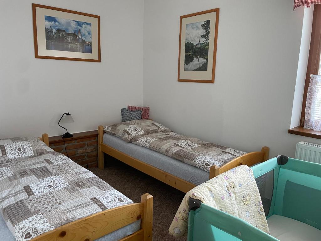 Un dormitorio con 2 camas y una silla. en Apartmán u Čarků 
