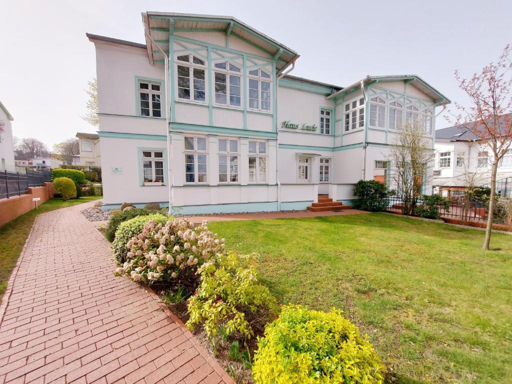 a large white house with a brick driveway at Haus Lucie 50m bis zum Ostseestrand in Heringsdorf