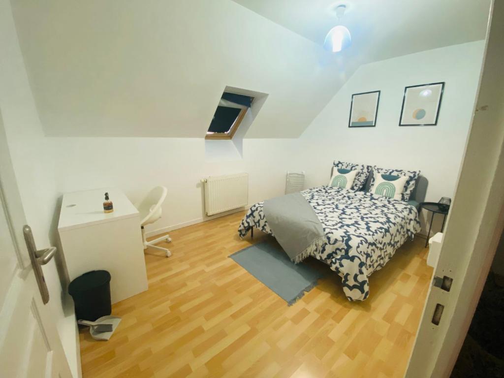 a bedroom with a bed and a desk in it at Maison calme et fonctionnelle business sportifs et familles PAS DE FETE in Corbeil-Essonnes