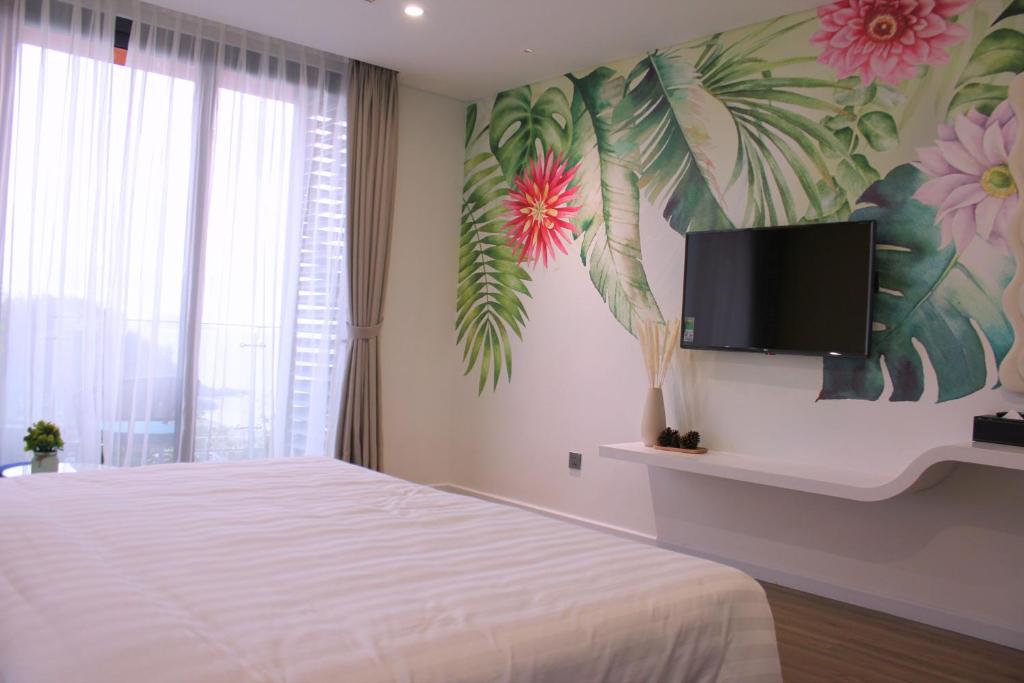 sypialnia z łóżkiem i telewizorem na ścianie w obiekcie Flamingo Hải Tiến- Thanh Hóa w mieście Nam Khê