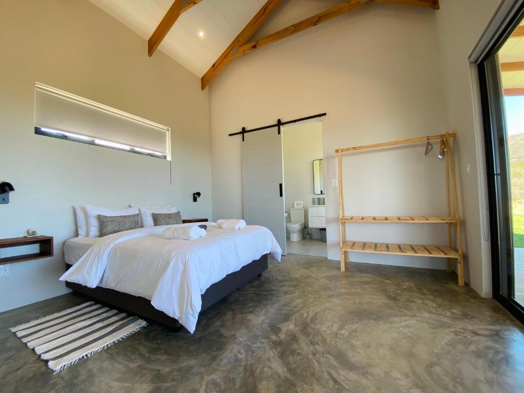 a bedroom with a large bed and a bathroom at Sneeukop Mountain Cottage in Paarl