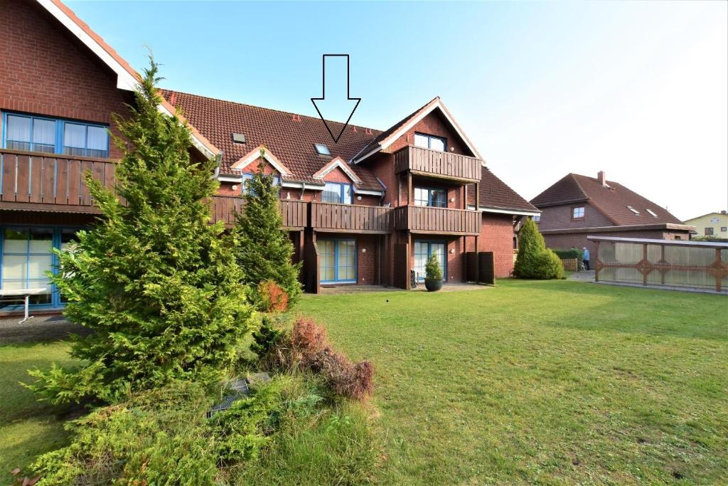 a house with a tree in front of it at FeWo StrandDomicil21 in Dahme