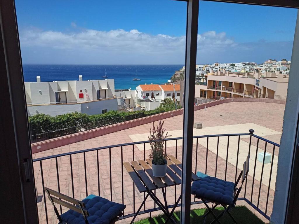 balcón con mesa, sillas y vistas al océano en Jandia Beach, en Morro del Jable