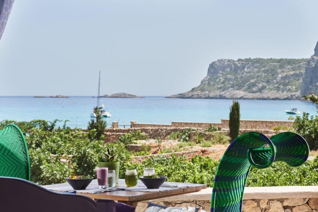 a table with chairs and a view of the ocean at Aquagrand Exclusive Deluxe Resort Lindos - Adults only in Lindos