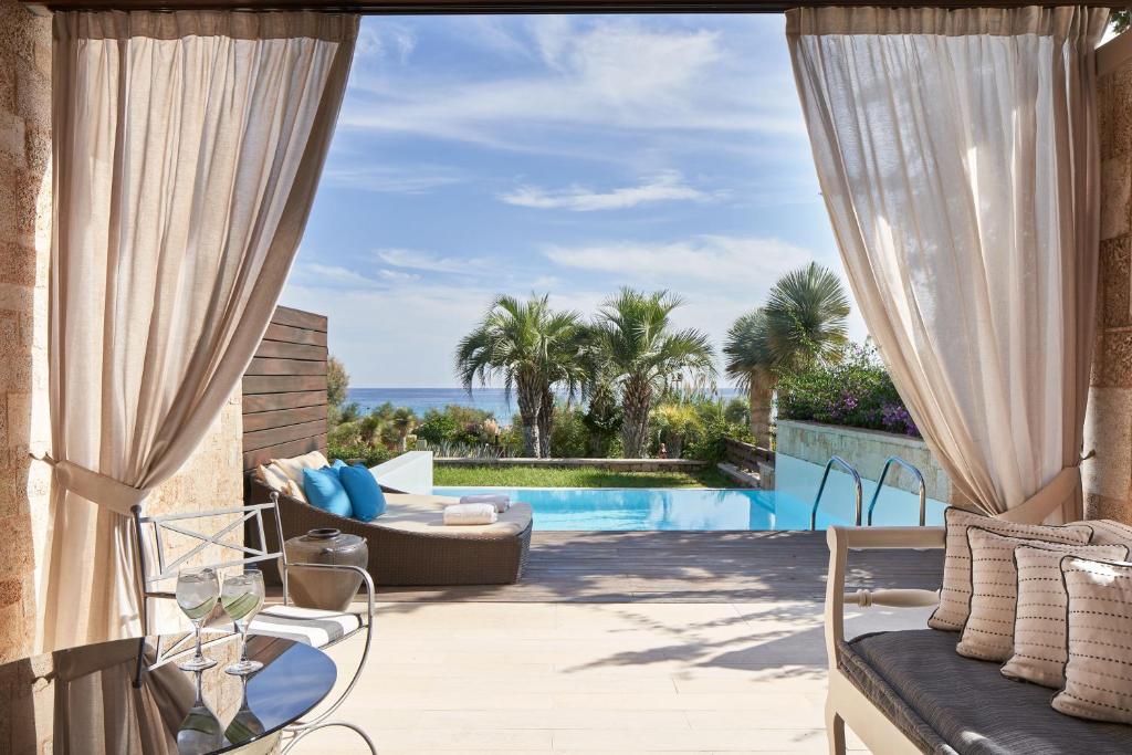 a patio with a view of the ocean from a villa at Aquagrand Exclusive Deluxe Resort Lindos - Adults only in Lindos