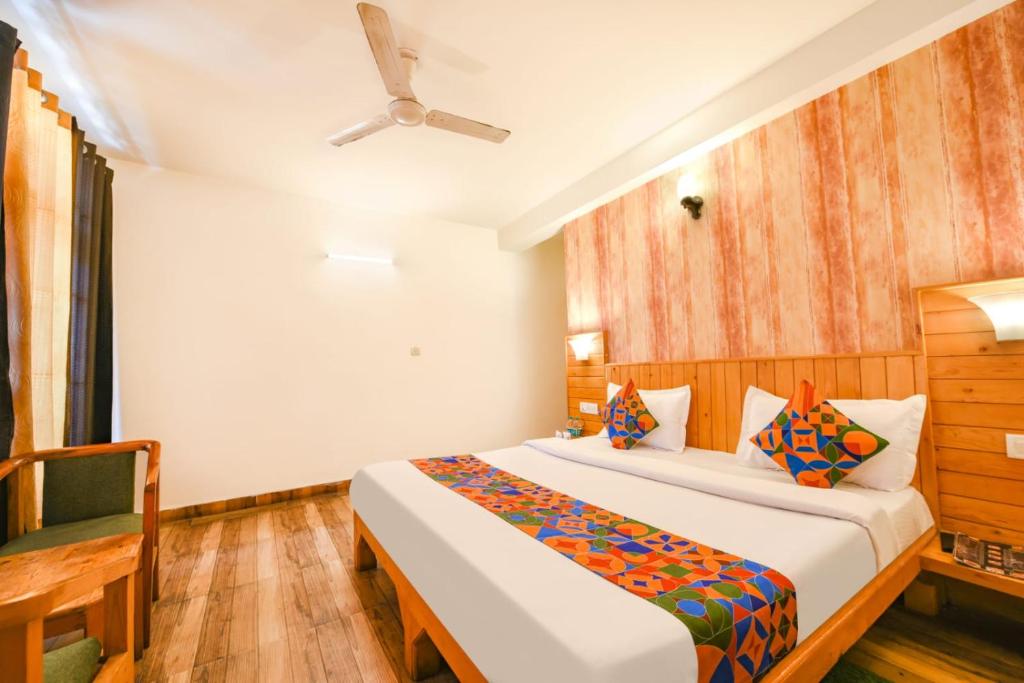 a bedroom with a bed and a ceiling fan at WooibHotels The Kanchanikoot Manali in Manāli