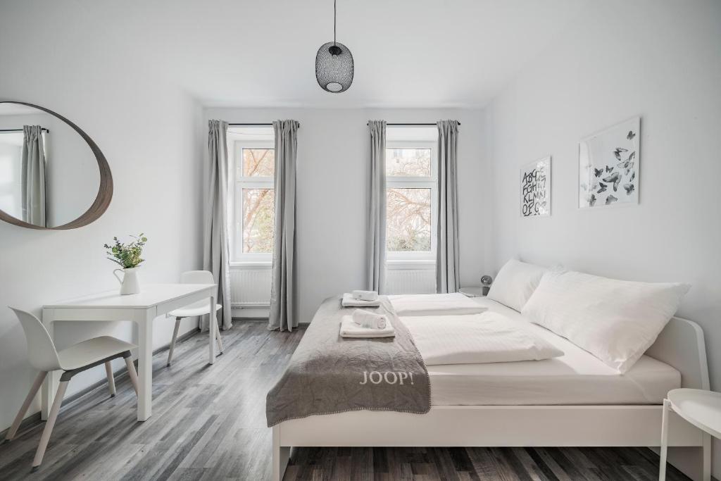 ein weißes Wohnzimmer mit einem Bett und einem Tisch in der Unterkunft cute apartment in vienna in Wien