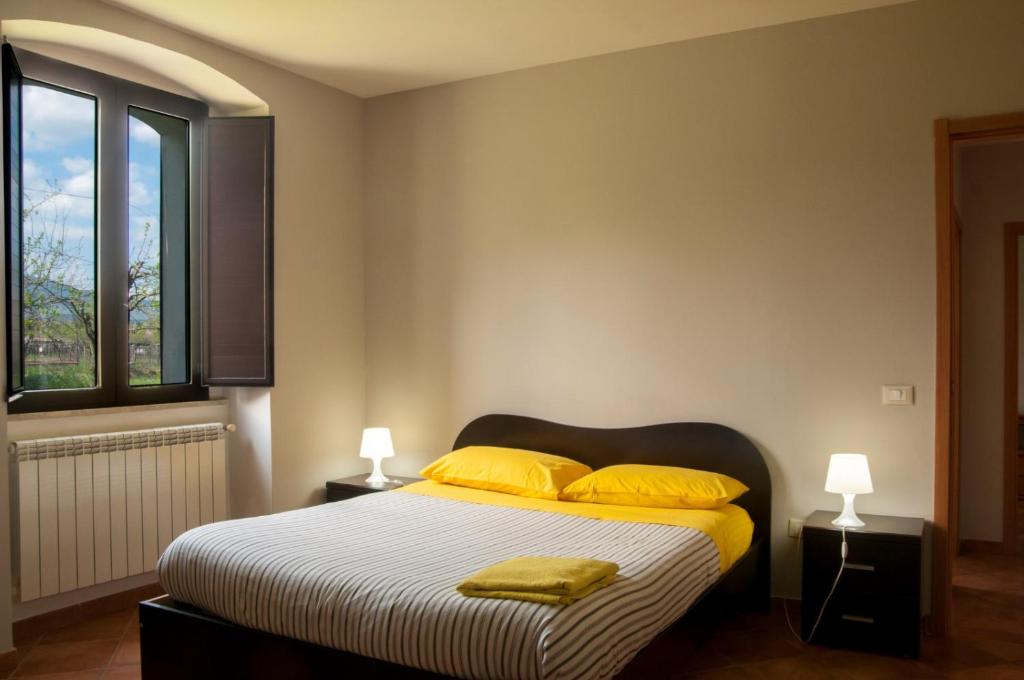 - une chambre avec un lit doté d'oreillers jaunes et d'une fenêtre dans l'établissement Appartamento Bojano, à Boiano
