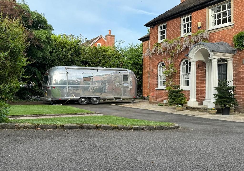 un remolque plateado estacionado frente a una casa en Airstream Experience en Knutsford