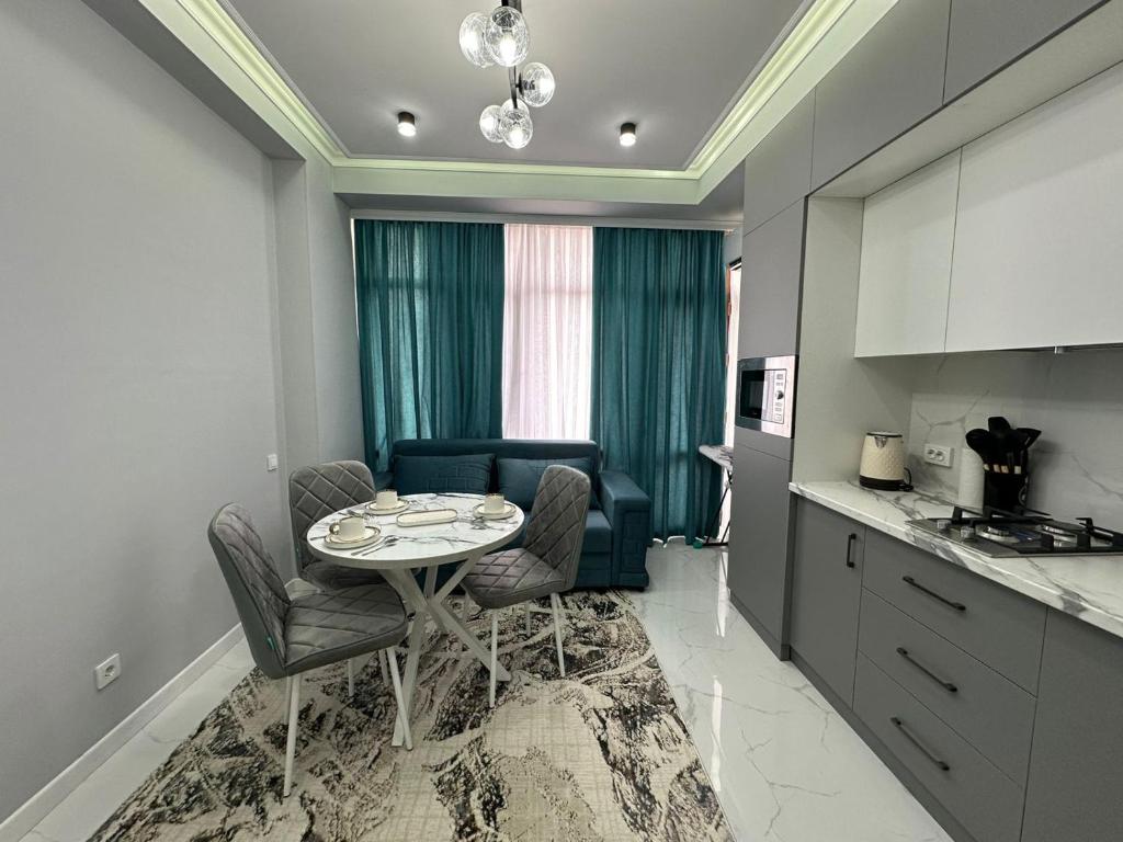 a kitchen with a table and chairs in a room at Жк Керуен Сарай 3 in Türkistan