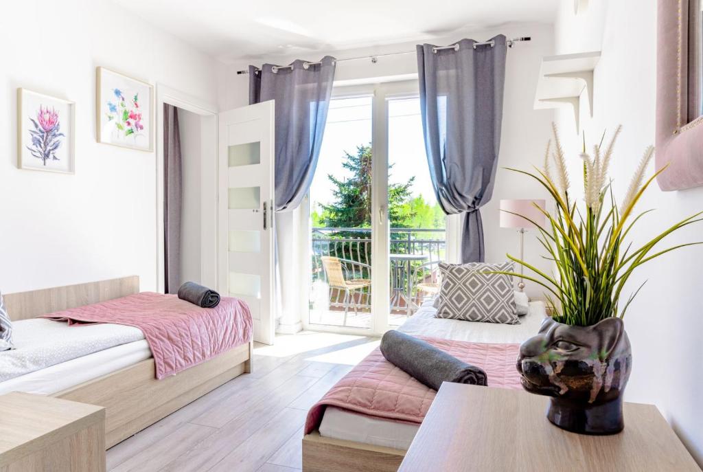 1 dormitorio con 2 camas y mesa en Willa Alexandria - Domki, Apartamenty, Pokoje z Basenem, en Karwia