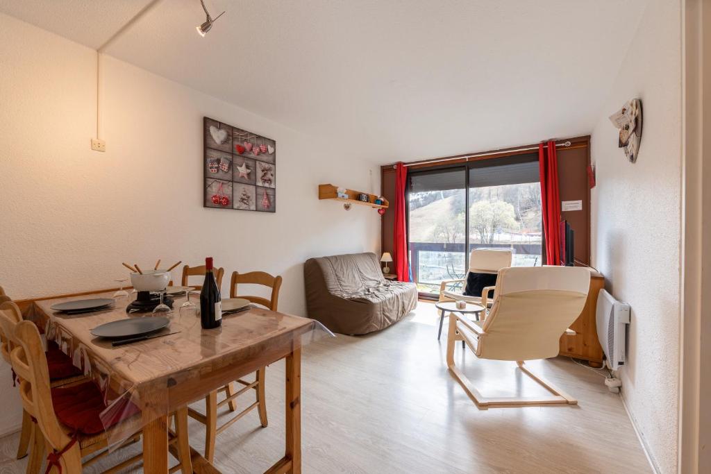 a living room with a wooden table and chairs at Le Corbier - studio avec belle vue montagne in Villarembert