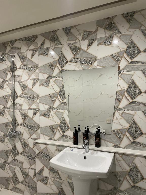 La salle de bains est pourvue d'un lavabo et d'un miroir. dans l'établissement Montage Apartments, à Rāmkot