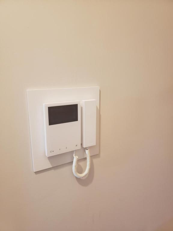 a white phone hanging on a wall at Indomitable in Colindale