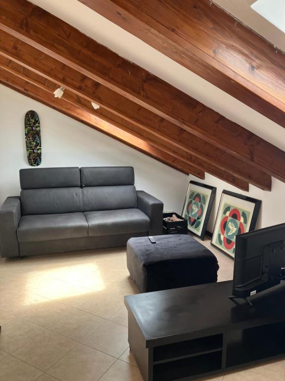 a living room with a couch and a tv at La Mansarda di Jt in Varazze
