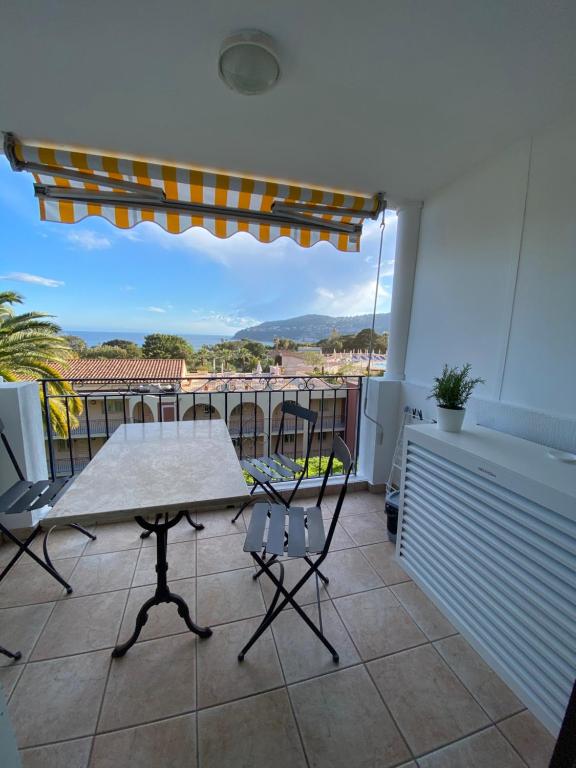 une table et des chaises sur un balcon avec vue dans l'établissement Appartement vue mer, à Villefranche-sur-Mer